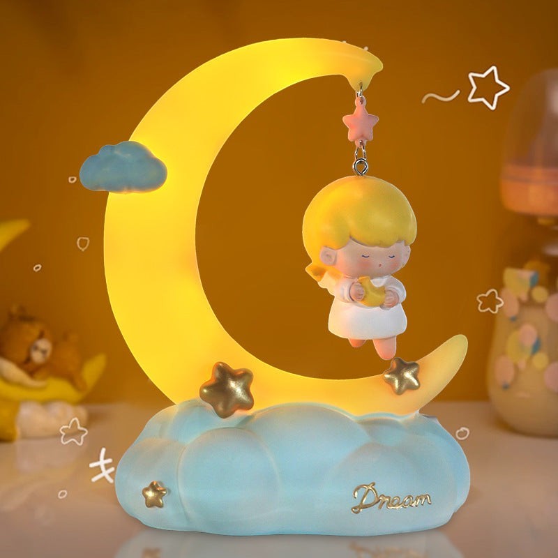 LX EMPIRE Good Night Little Angel night light with a girl holding a moon on a crescent moon, stars, and clouds. Resin and plastic.