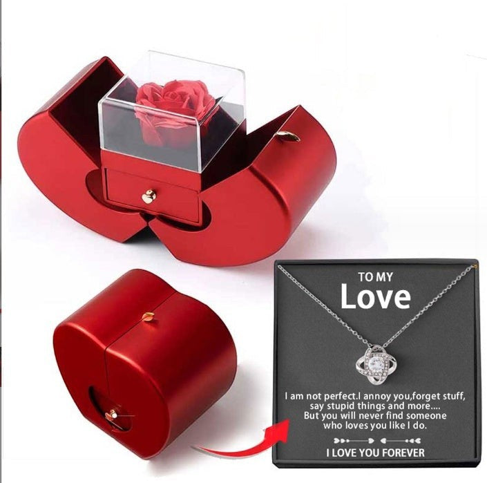LX EMPIRE red heart-shaped jewelry box with preserved rose and a silver necklace with a knot pendant.