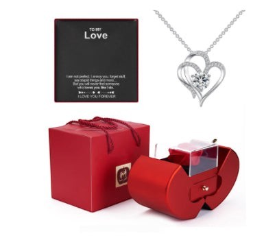 LX EMPIRE silver heart pendant necklace with cubic zirconia, presented in a red apple-shaped jewelry box with a gift bag.